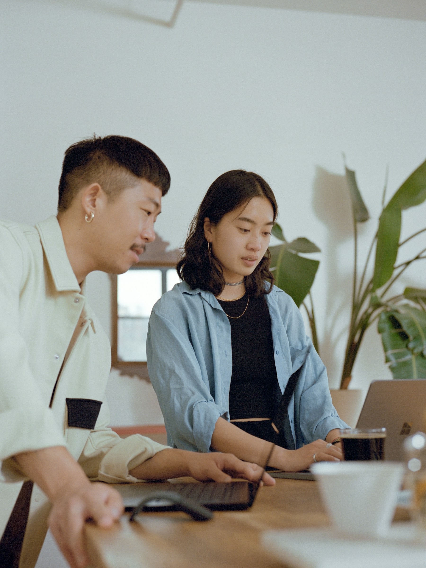 Two colleagues working through a task together on a laptop