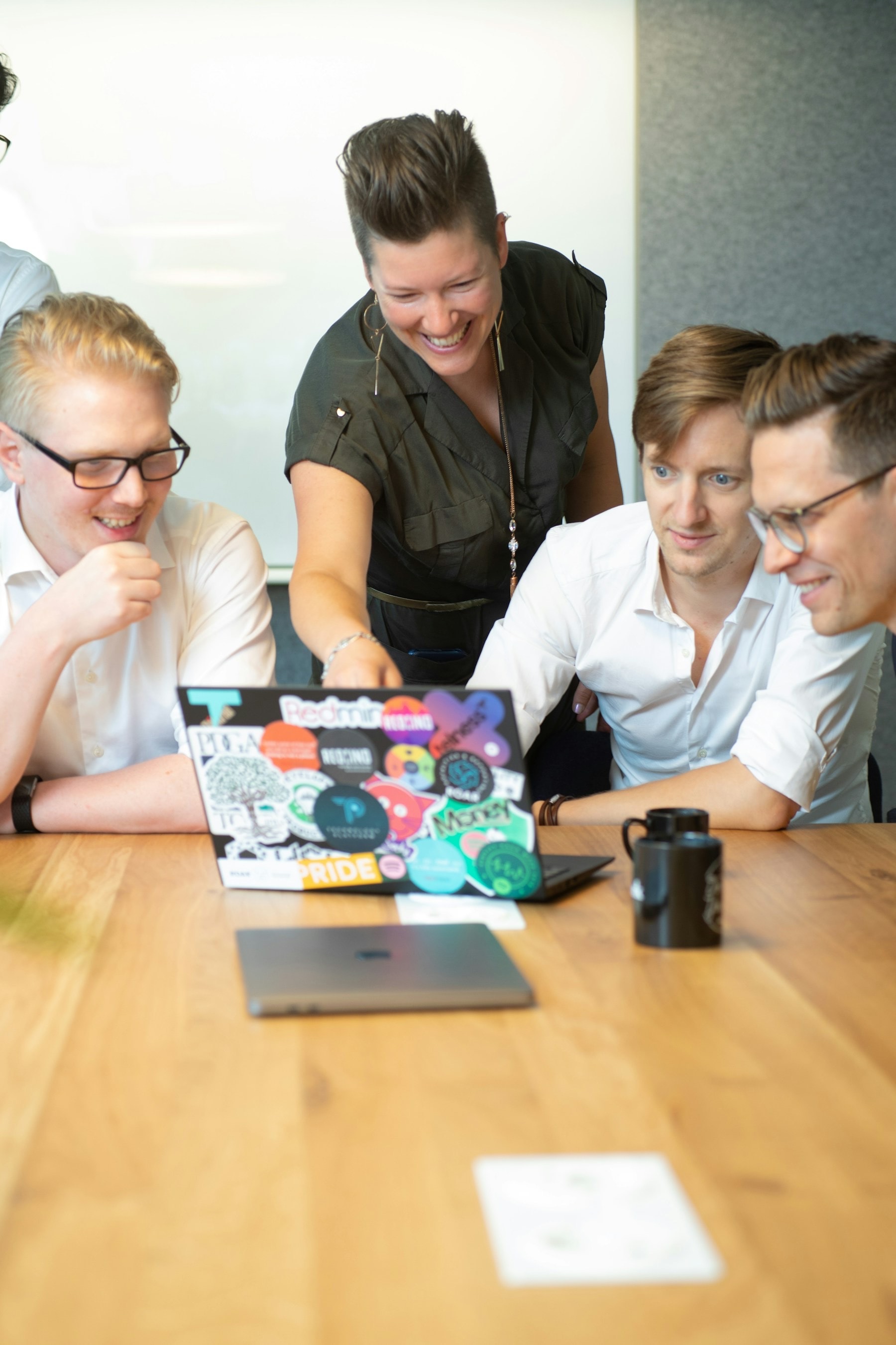 A team gathered around a laptop in a bright office